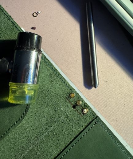 olive leather folio inserting grommets - FORTÉ x Penelope leather folio collaboration